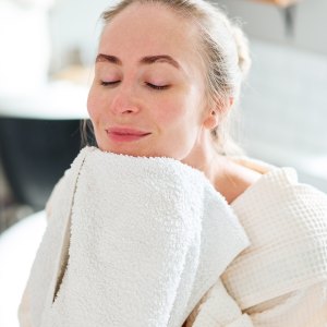 Woman wiping face in bathroom