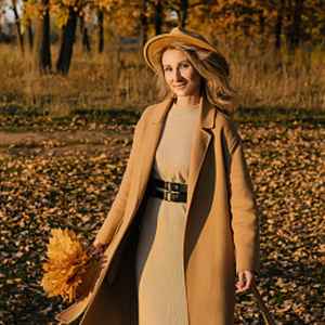 woman wearing beige coat, dress and hat in the fall