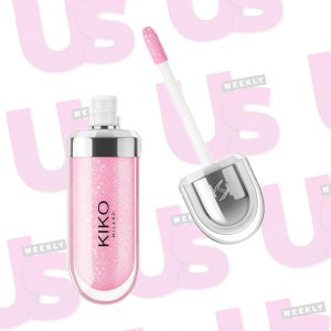 A pink lip gloss in front of a UsWeekly background.
