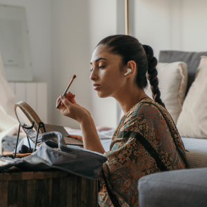 a woman applying makeup in the bedroom