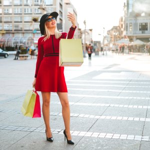 woman in a red dress taking a selfie on the street
