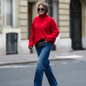 woman wearing loose red sweater and blue jeans