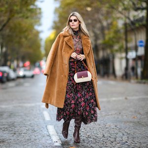 woman wearing floral fall dress and tan coat
