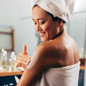 Woman Putting On Cream After A Shower