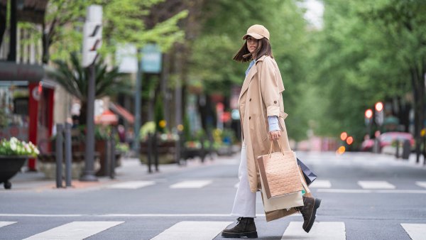Young woman with shopping bags walking on road