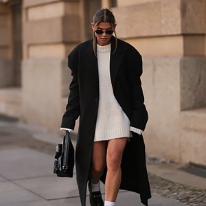 BERLIN, GERMANY - OCTOBER 15: Sophia Geiss is seen wearing oval rimless black sunglasses from Vehla Eyewear; two different-sized gold hoop earrings; a silver nose ring; an ankle-length, oversized black coat with shoulder-ads and notch lapels from 032c; an oversized knit pullover with high round neckline from Black Palms underneath; a rectangular black leather handbag featuring two small pockets of various sizes and a short leather strap from Liebeskind Berlin; and white socks paired with black leather loafers with silver horsebit buckle from LeGer on October 15, 2024 in Berlin, Germany. (Photo by Jeremy Moeller/Getty Images)