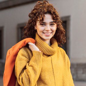 Smiling woman with shopping bags on footpath