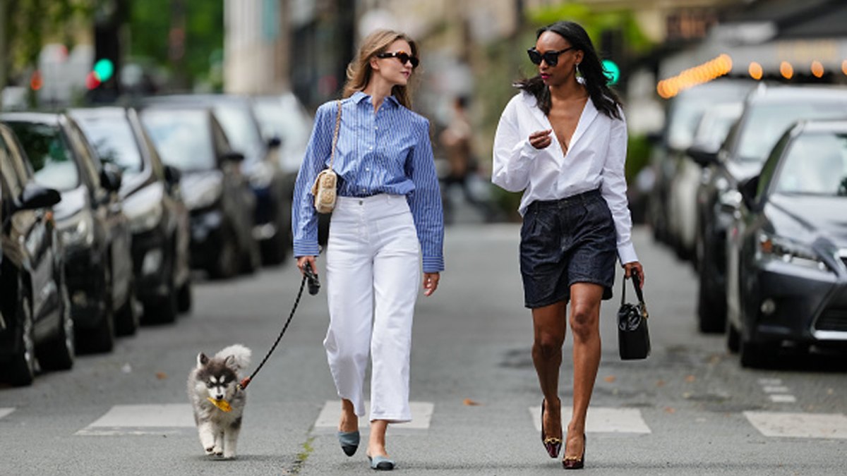 two women walking dog in city