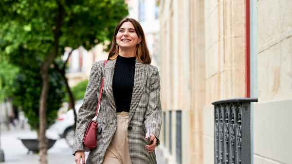 women wearing blazer walking on street