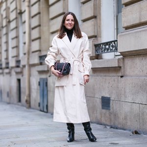 woman wearing cream jacket and black boots