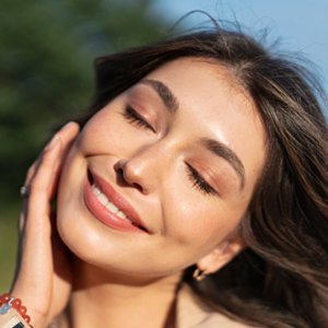 woman holding face with clean makeup