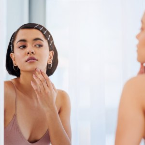 Shot of an attractive young woman going through her morning beauty routine at home