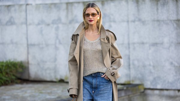 woman wearing sweater, trench coat and blue jeans