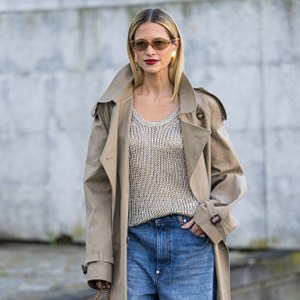 woman wearing sweater, trench coat and blue jeans