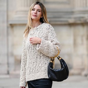 woman wearing fuzzy sweater and black bag