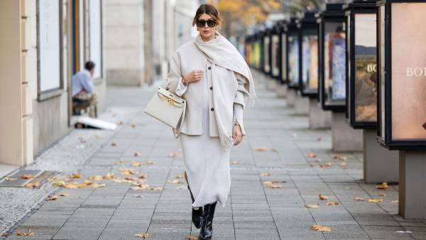Victoria Scheu wears knitted white dress H&M, scarf jacket with fringes Cos, sunglasses Givenchy, Kelly Bag Craie Hermes, black ankle boots on November 27, 2024 in Berlin, Germany.