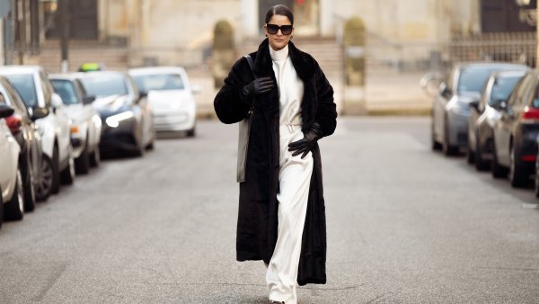 Gili Biegun wears silk cream long trousers and matching top with neck detail by Aeron, black leather square bag by Aeron, black sunglasses by Kaleos, long black leather gloves, extra large faux fur coat and Anna Rossi earrings, and Saint Laurent heels on December 03, 2024 in Copenhagen, Denmark.