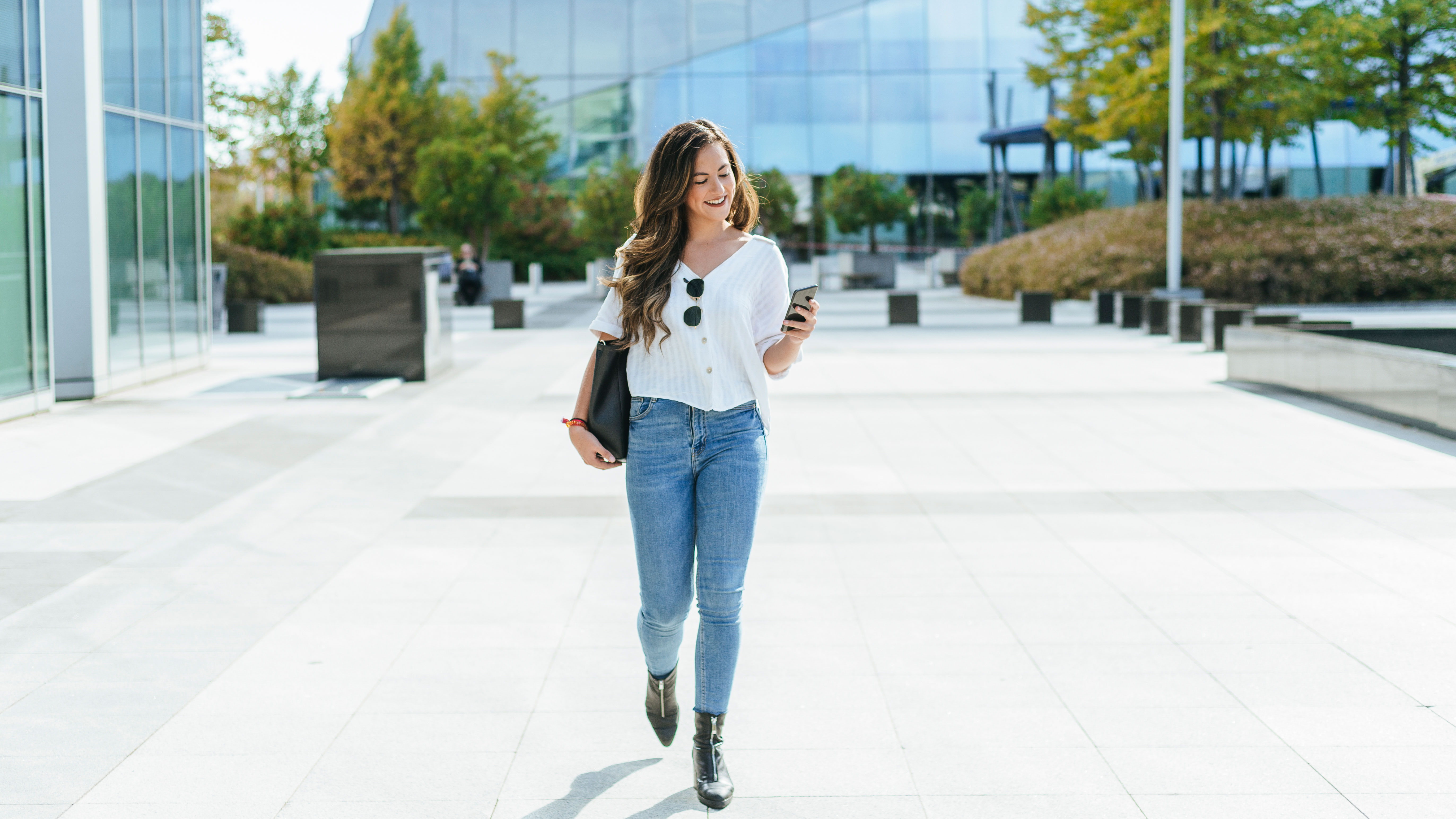 Business woman walked while using smartphone.