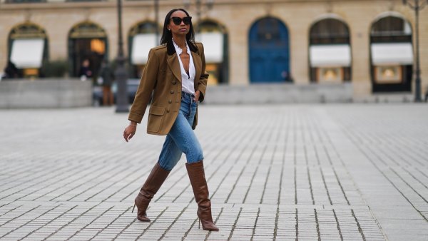 woman wearing blue jeans, brown jacket and boots