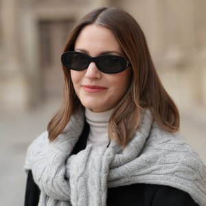 PARIS, FRANCE - DECEMBER 04: Marissa Cox wears black sunglasses, a white turtleneck pullover, a grey hoodie, a black blazer jacket, during a street style fashion photo session, on December 04, 2024 in Paris, France. (Photo by Edward Berthelot/Getty Images)