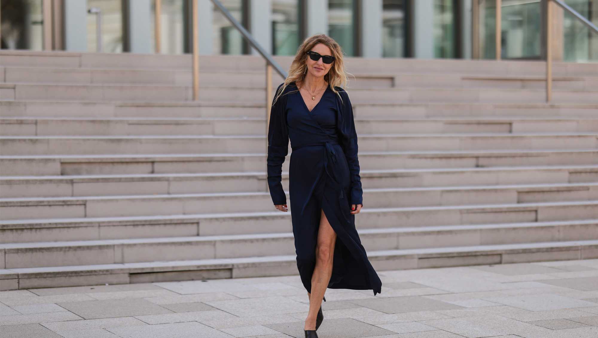 Sue Giers seen wearing a black Celine sunglasses, a dark blue silk midi dress from SoSue and black leather Bottega Veneta heels on June 09, 2022 in Hamburg, Germany.