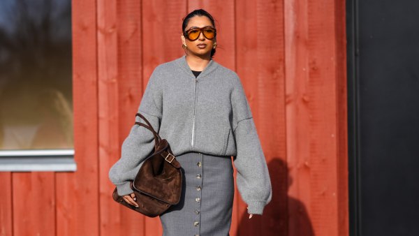 COPENHAGEN, DENMARK - FEBRUARY 01: A guest wears sunglasses, earrings, a gray wool oversized cardigan, a brown suede bag, a gray long slit skirt , brown leather boots , outside Gestuz, during the Copenhagen Fashion Week AW24 on February 01, 2024 in Copenhagen, Denmark. (Photo by Edward Berthelot/Getty Images)