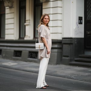 woman wearing beige sweater and white pants