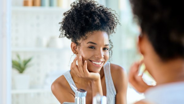 Shot of an attractive young woman admiring herself in the bathroom mirror during her morning beauty routine