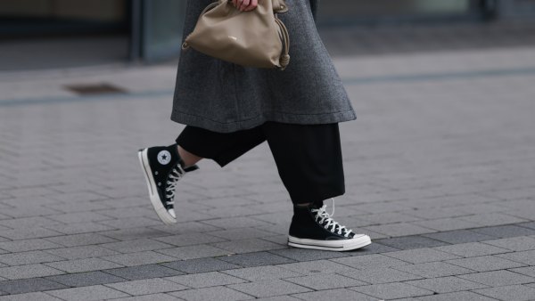 DUESSELDORF, GERMANY - NOVEMBER 08: Maria Barteczko is seen wearing oversized square-shaped aviator glasses with a black frame and narrow silver temples from Victoria Beckham; small chunky hoop earrings in silver from COS; an oversized grey wool coat with notch lapels and large pockets from WENDKYKEI; underneath a black t-shirt with a round neckline paired with black wide-legged culotte pants, both from WENDYKEI; a “Flamenco“ clutch bag in light khaki leather from Loewe; and black high top “All Star Chucks“ from Converse on November 08, 2024 in Duesseldorf, Germany. (Photo by Jeremy Moeller/Getty Images)
