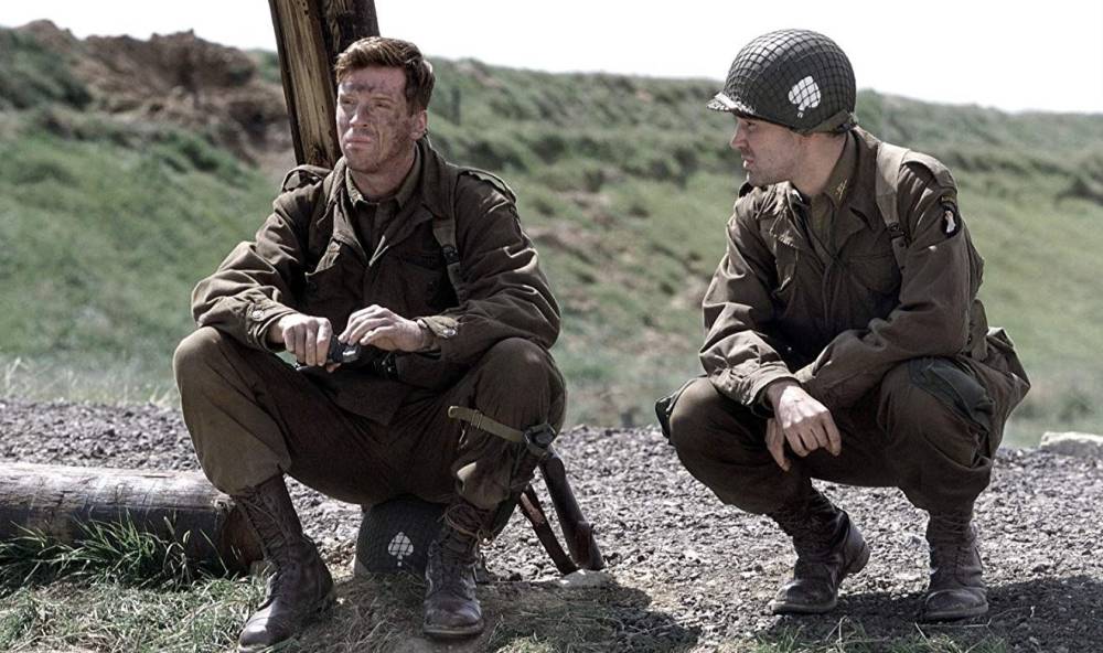 Two soldiers squat in Band of Brothers.