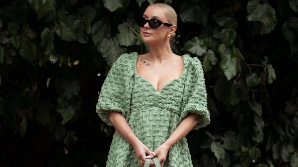 COPENHAGEN, DENMARK - AUGUST 9: Justyna Czerniak wears black sunglasses, a green embossed pattern puffy short sleeves long dress, beige and green khaki Loewe, brown shiny leather shoes outside Stine Goya during the Copenhagen Fashion Week Spring/Summer 2024 on August 9, 2023 in Copenhagen, Denmark. (Photo by Raimonda Kulikauskiene/Getty Images)