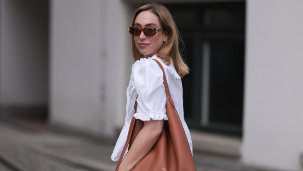 BERLIN, GERMANY - JUNE 11: Sonia Lyson is seen wearing sunglasses with havana frame from Givenchy, silver earrings, a golden necklace, a white blouse with puffed sleeves and ruffled details from Horror Vacui, cream-white wide linen pants from Zara and the “Low Key Hobo” bag in brown leather from Louis Vuitton on June 11, 2024 in Berlin, Germany. (Photo by Jeremy Moeller/Getty Images)