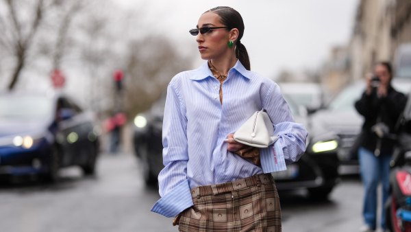 PARIS, FRANCE - MARCH 10: Ginevra Mavilla wears black sunglasses, dark green earrings, dark brown Marine Serre monogram Marine Serre buttoned up long sleeve shirt, light blue navy blue striped half buttoned long sleeve Marine Serre shirt, white clutch leather bag, outside Marine Serre, during the Paris Fashion week Women's Fall/Winter 2025-2026 on March 10, 2025 in Paris, France. (Photo by Edward Berthelot/Getty Images)