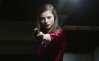 A girl aims a gun in Eileen.