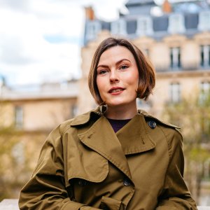 Portrait of a beautiful young woman standing on the street in front of an Eiffel Tower in Paris in France.