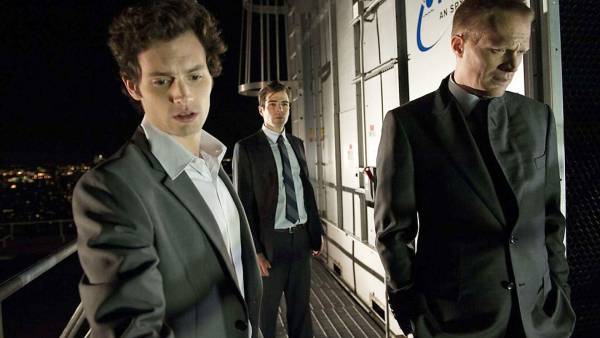 Three men stand on a roof at night in Margin Call.