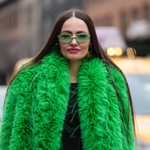 NEW YORK, NEW YORK - FEBRUARY 08: A guest wears bright green sunglasses, bright green faux fur coat, shiny black straight leather pants, outside Alice + Olivia, during the New York Fashion week Fall/Winter 2025 on February 8, 2025 in New York, New York. (Photo by Edward Berthelot/Getty Images)