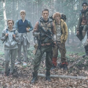 A group of teens stand in the woods in The Rain.