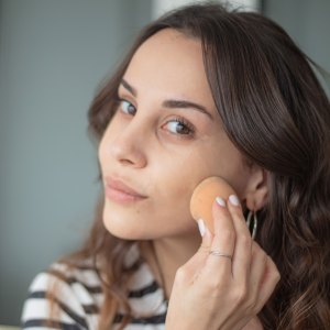 Young woman is doing a make-up. - stock photo