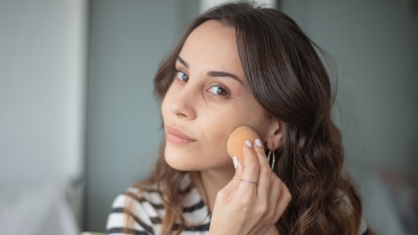 Young woman is doing a make-up. - stock photo