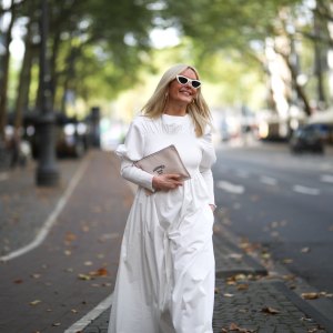 Judith Mosqueira do Amaral wearing Toteme dress, Ariane Ernst earring, Balenciaga sneaker, Hermes clutch and Celine shades on August 14, 2020 in Cologne, Germany.