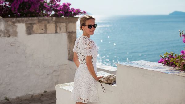Woman at the seaside, turning around with a smile