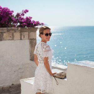 Woman at the seaside, turning around with a smile