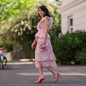 Anna Wolfers wearing white and pink ruffle dress via Goldig Shop, pink Moschino clutch and pink heels on May 31, 2021 in Hamburg, Germany.