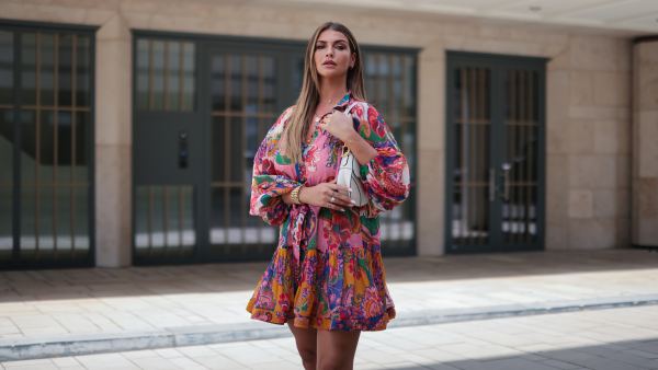 Farina Opoku wearing pink floral Zimmermann mini dress and white Dior saddle bag poses on June 18, 2021 in Cologne, Germany.