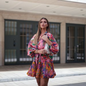 Farina Opoku wearing pink floral Zimmermann mini dress and white Dior saddle bag poses on June 18, 2021 in Cologne, Germany.