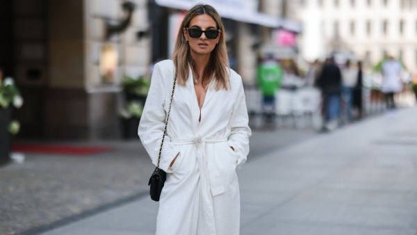 Anna Winter wearing black RayBan shades, white coat, white pants and black Chanel leather bag on July 12, 2021 in Berlin, Germany.