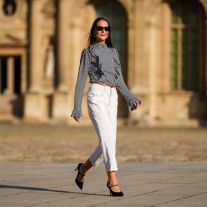 Alba Garavito Torre wears a gingham checkered black and white shirt with Long Sleeve Ruffles from Serendipia, Mom jeans in white from Maison 123 Paris, a brown leather thin belt, Black Mary Jane high heels shoes from Gucci, on October 10, 2021 in Paris, France.