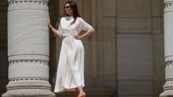 Gabriella Berdugo wears sunglasses, a white long gathered dress with a scarf from Gestuz, red kitten heels mule shoes with open toe from Age of Innocence, during a street style fashion photo session, on May 16, 2024 in Paris, France.