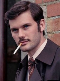 A man smokes a cigarette in Dalgliesh.